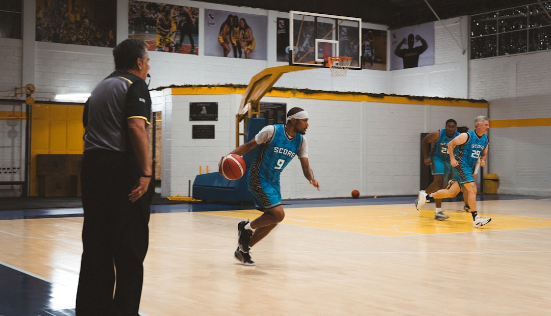 Basketball player driving past a coach on an indoor court