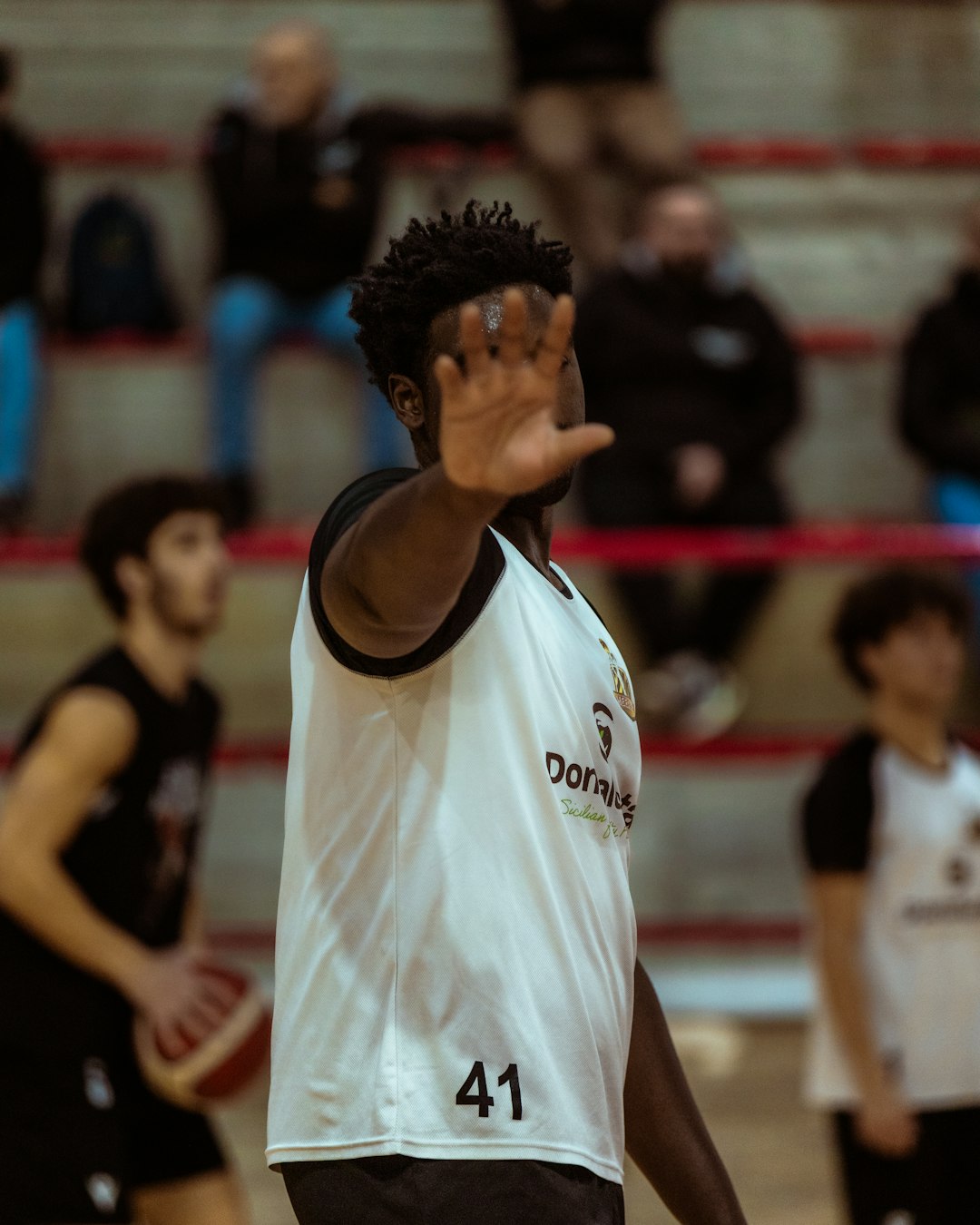 Basketball player holding a hand up during a game